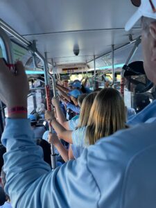 Passengers of a public transit bus hold on to supports. 