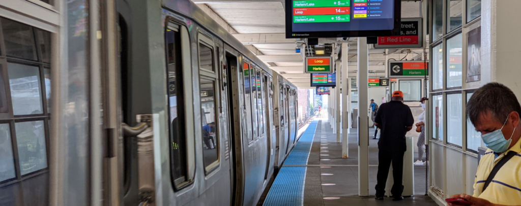 People waiting at the CTA Red and Green Line stop with masks on