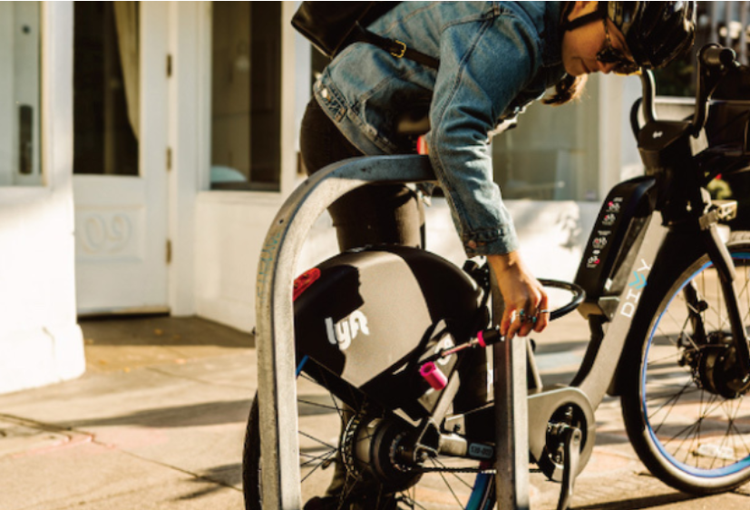 Man locking Divvy/Lift E-Bike to bike rack