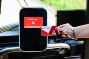 A passenger tapping their transit card to a fare collection system. 