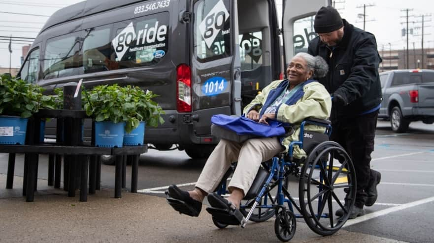 Photo of an elderly woman in a wheelchair near a Ford GORIDE van