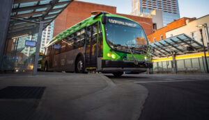 A bus waiting outside of a bus depot. 