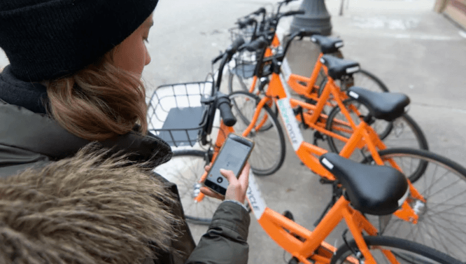 Woman checking out Koloni bike on smartphone