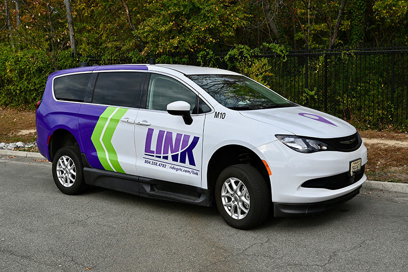 a parked purple and white van with LINK on the side