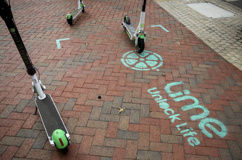 Image of Lime Scooters with promotion of Lime painted with chalk on brick sidewalk