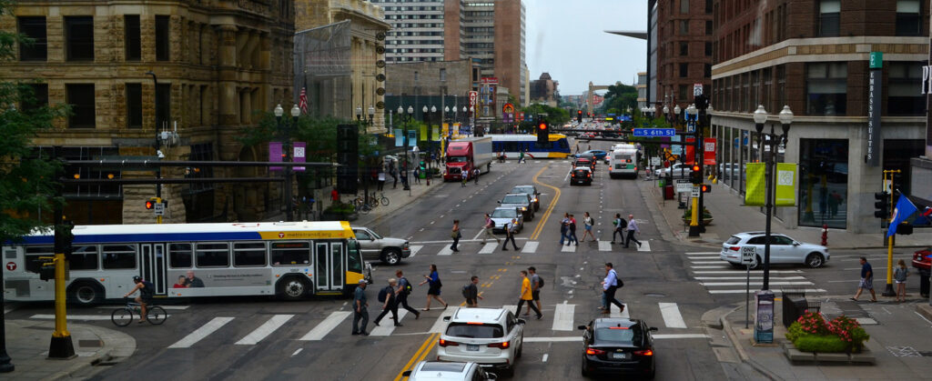 Image of pedestrians, buses, cars, and trucks on Minneapolis city street