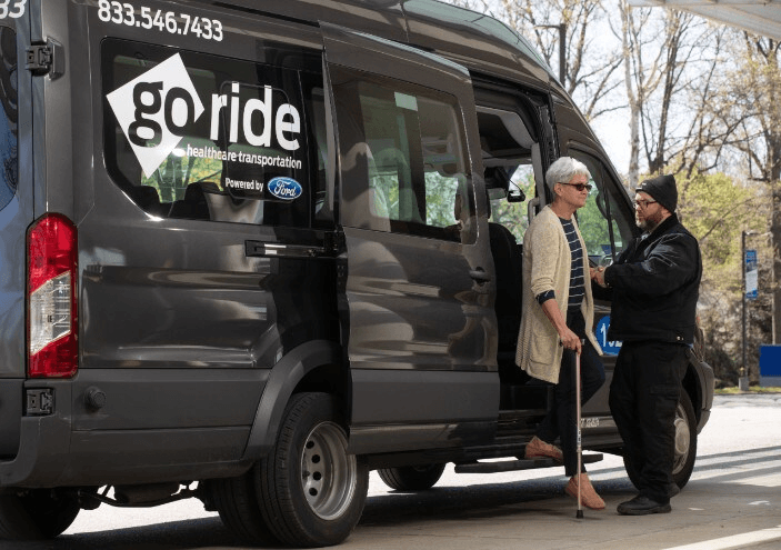 Elderly woman exiting Ford GORide Van