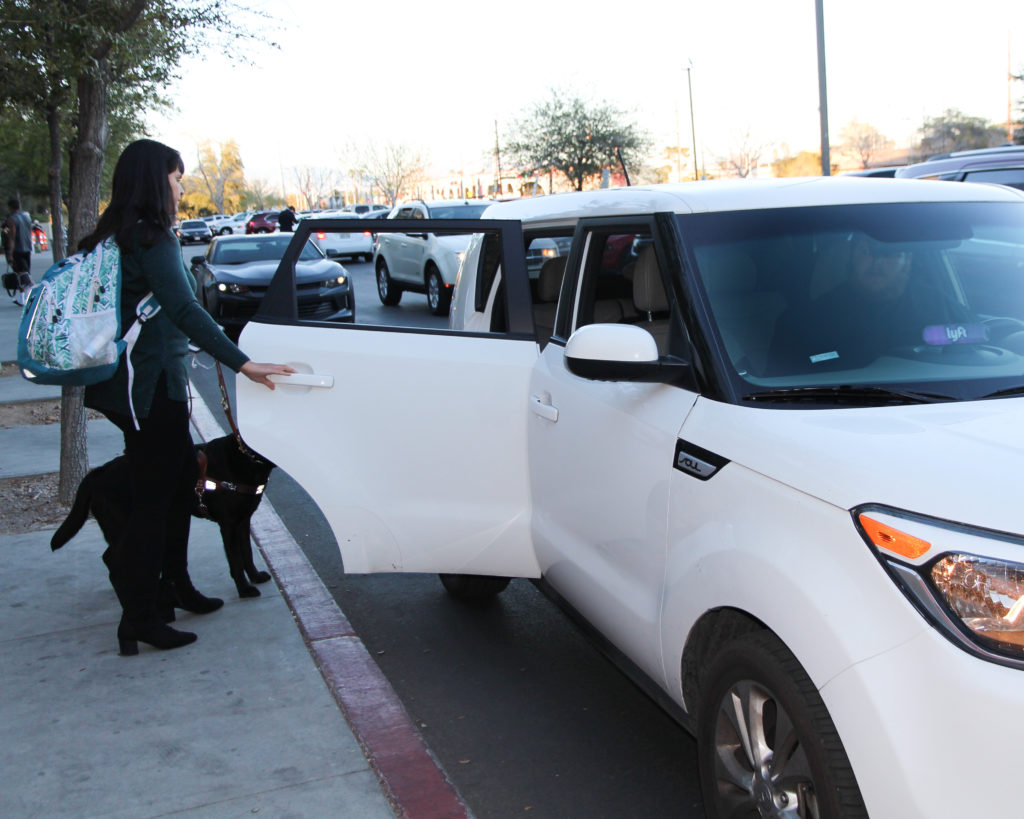 A visually impaired person entering a vehicle