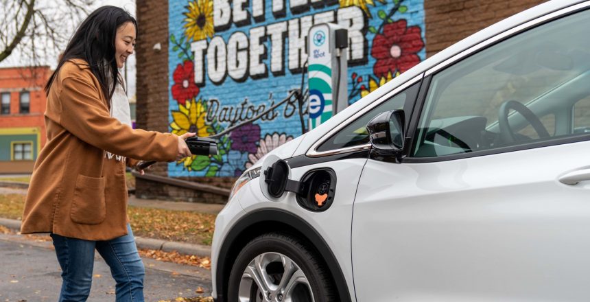 Image of individual with charge at Evie Carshare vehicle