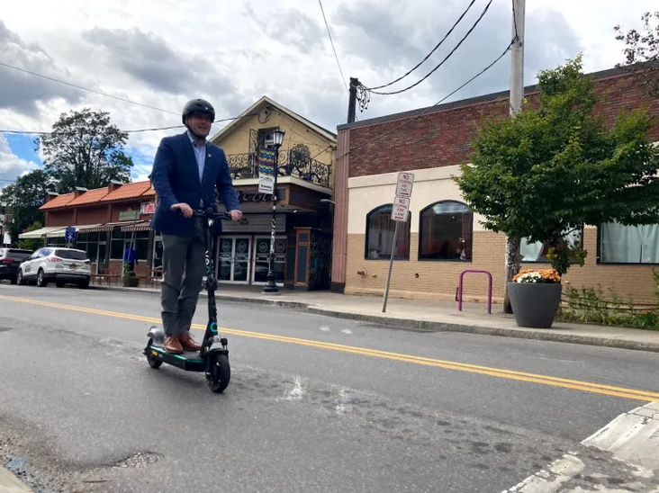 Image of man riding a Veo scooter