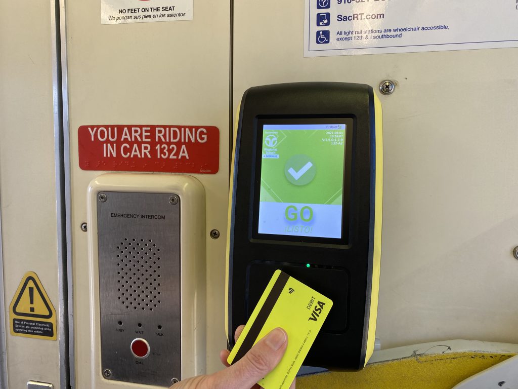 Image of passenger tapping contactless debit card to payment receptor on SacRT Light Rail