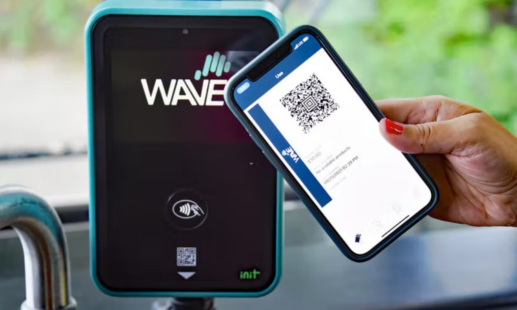Indivudal tapping their smartphone on the Wave Payment System Scanner