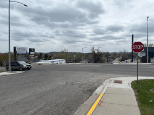 a car drives through an intersection. there is a stop sign in the foreground