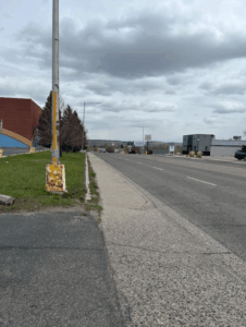an uneven sidewalk next to a four lane road