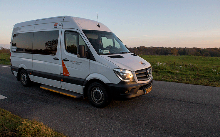 A picture of a FlexTrafik shuttle driving in a rural area of Denmark