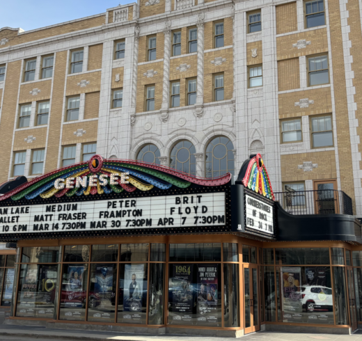 The front of a large theater building with the words "Genesee" on the front, and "Swan Lake Ballet, Medium Matt Fraser, Peter Frampton, and Brit Floyd" on the marquee