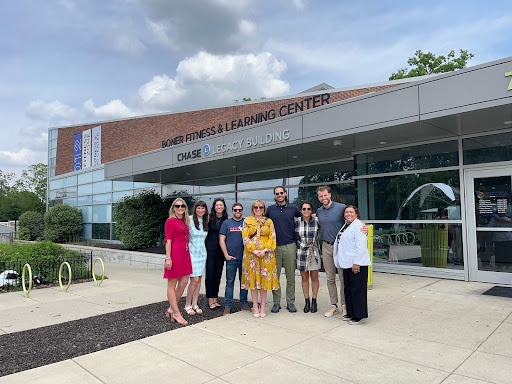 nine people stand in front of a building with the words Boner Fitness & Learning Center above the doors