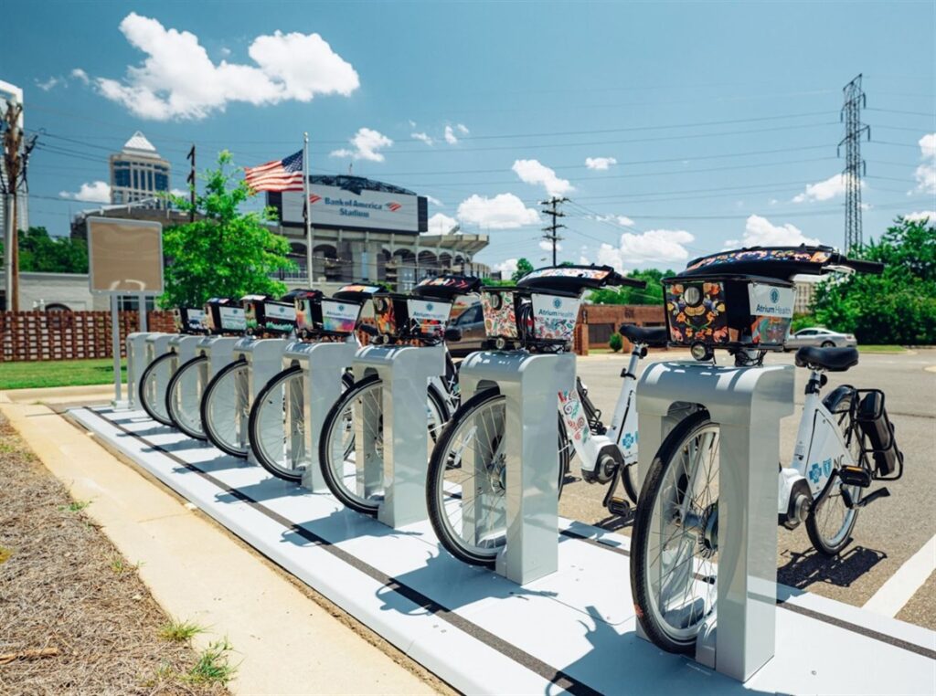 seven bikeshare bikes parked at a white smart dock