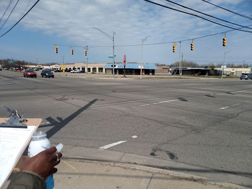 A large 4-way intersection with two cars waiting at a red light