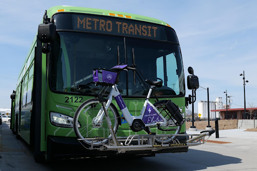 Front of a Metro Transit Bus with a Heartland Bike Share bike on its bike rack.