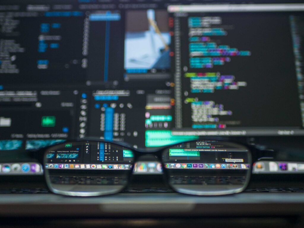Stock photo of glasses on laptop with data processing programs on screen