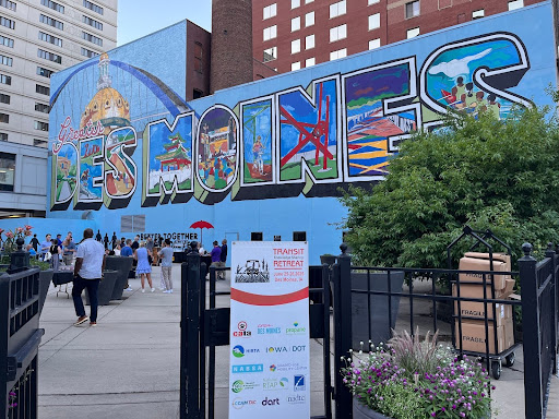 A colorful mural on the side of a building with the words "Des Moines"