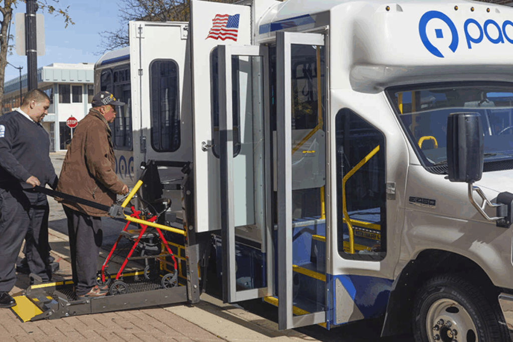 A transit operator assisting a passenger with a mobility device into a paratransit vehicle