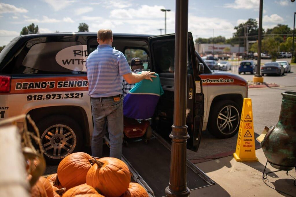 a man assists a person in a wheelchair into a van