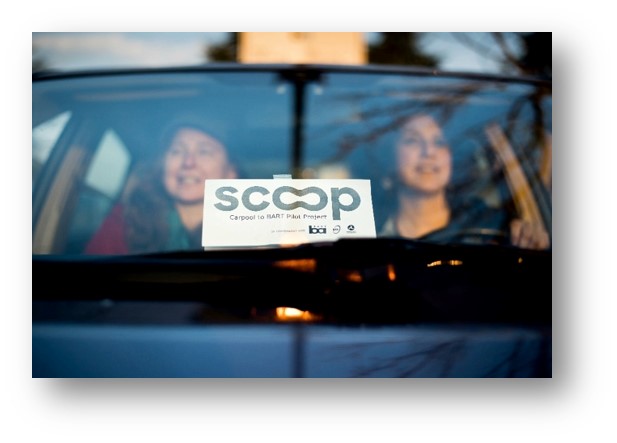 Photo of two people carpooling and the Scoop parking pass shown on the dashboard.