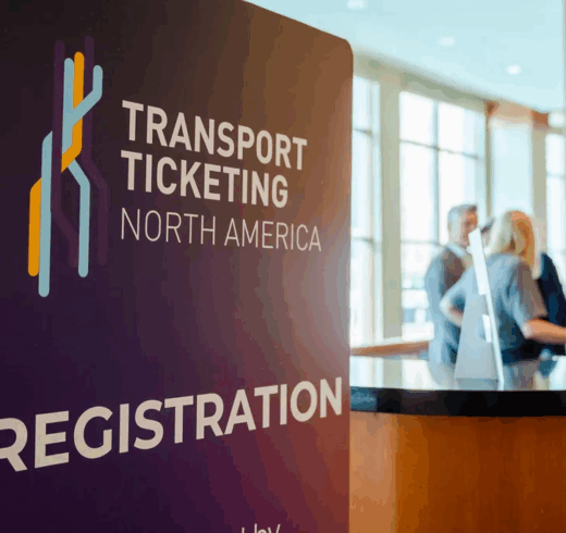 a banner reading "Transport Ticketing North America" and "Registration" next to a desk with two people behind it